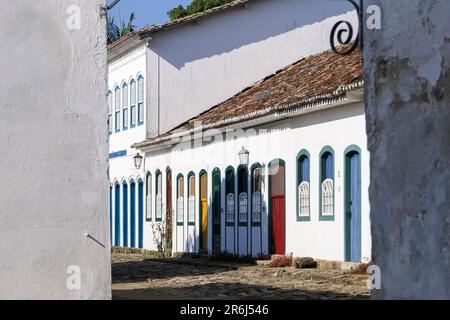 Vue encadrée sur un ensemble de maisons coloniales le long d'une rue pavée par une journée ensoleillée dans la ville historique de Paraty, Brésil, patrimoine mondial de l'UNESCO Banque D'Images