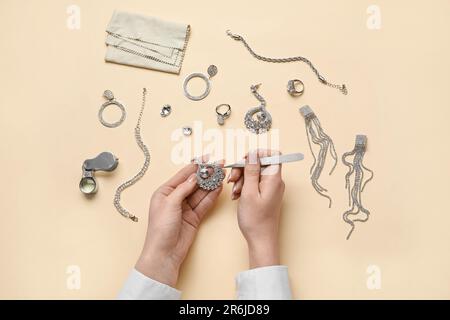 Femme nettoyant des accessoires élégants sur fond de couleur Banque D'Images