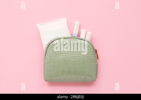 Sac cosmétique Lady's avec tapis menstruels et tampons sur fond rose Banque D'Images