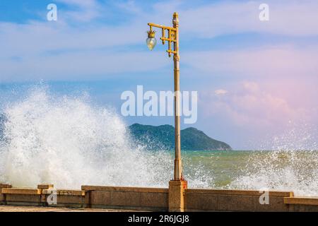 Surf puissant, vagues hautes avec des éclaboussures, une mer qui fait rage, une lanterne sur le remblai. Banque D'Images