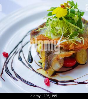 Filet de bar poêlé croustillant aux graines de grenade et vinaigre balsamique Banque D'Images