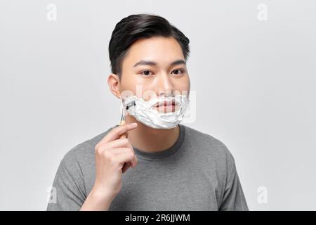 Beau homme appréciant la routine de bain du matin, s'occuper de l'apparence, peau du visage saine Banque D'Images