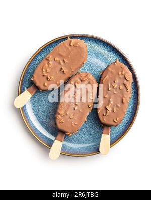 Popsicle, crème glacée recouverte de chocolat sur plaque isolée sur fond blanc. Banque D'Images