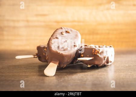 Popsicle, glace recouverte de chocolat sur la table en bois. Banque D'Images