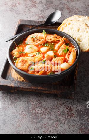 Un épais ragoût méditerranéen de fruits de mer et de poissons avec des tomates dans un bol sur la table. Verticale Banque D'Images