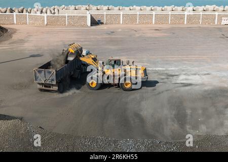 Ciment de chargement de pelle hydraulique sur le quai divers et Bulk du port de Laayoune Banque D'Images