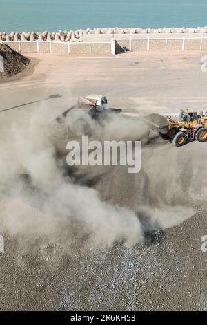 Ciment de chargement de pelle hydraulique sur le quai divers et Bulk du port de Laayoune Banque D'Images