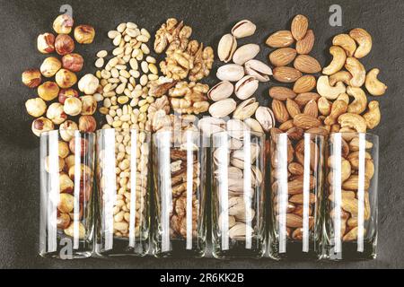 Trois pots en verre contenant différents types de noix sont placés sur un comptoir de cuisine Banque D'Images