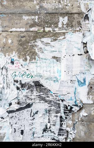 Mur en béton avec affiches de facture déchirée colorées. Grunge l'arrière-plan Banque D'Images