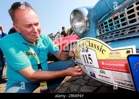 Wolmirstedt, Allemagne. 10th juin 2023. Le lanceur Michael Wesemann attache sa plaque de départ pour le Classic Ohre 13th à son Wartburg. 110 participants prennent part à la rencontre voiture classique avec leur voiture. Depuis le point de départ du château de Wolmirstedt, les amateurs de voitures classiques traverseront cette année le nord de Saxe-Anhalt. Credit: Peter Gercke/dpa/Alay Live News Banque D'Images