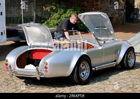 Wolmirstedt, Allemagne. 10th juin 2023. Un participant vérifie sa voiture classique Cobra avant le début de l'Ohre Classic 13th. 110 participants prennent part à la rencontre voiture classique avec leur voiture. Depuis le point de départ du Schlossdomäne Wolmirstedt, les amateurs de voitures classiques traverseront le nord de Saxe-Anhalt cette année. Credit: Peter Gercke/dpa/Alay Live News Banque D'Images