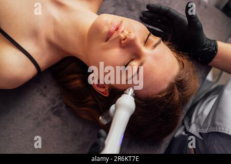 Femme caucasienne obtenant la procédure de peeling du visage dans une clinique de beauté, gros plan. Soin liquide au gaz du visage rajeunissant. Opération de nettoyage de la peau Hydro air Banque D'Images