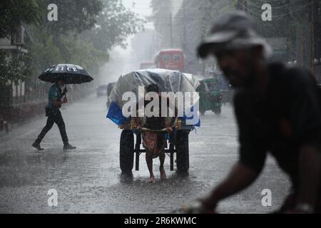 Pousse-pousse transportant le passager lorsqu'une femme de chambre à forte pluviométrie se trouve à dhaka, au Bangladesh, le 22march 2023.Nazmul islam/ alamy vivent Banque D'Images