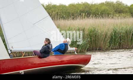 Horning, Norfolk, Royaume-Uni – 03 juin 2023. Gros plan d'un homme et d'une femme qui naviguent sur un voilier traditionnel le long de la rivière Bure tout en concourant dans le 2023 thre Banque D'Images