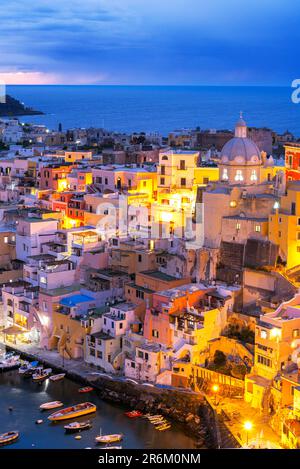 Village de pêcheurs illuminé de Marina Corricella au crépuscule, île de Procida, mer Tyrrhénienne, quartier de Naples, baie de Naples, Campanie, Italie, Europe Banque D'Images