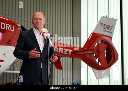 Nuremberg, Allemagne. 10th juin 2023. Le chancelier allemand OLAF Scholz (SPD) parle dans un micro nommé « DRF Luftettung » dans un hangar de l'aéroport Albrecht Dürer de Nuremberg. Derrière lui se trouve un hélicoptère de sauvetage. Le chancelier a visité les deux stations de la DRF Lufttrettung à Nuremberg et a fait l'éloge de l'excellent équipement technique. Credit: PIA Bayer/dpa/Alay Live News Banque D'Images