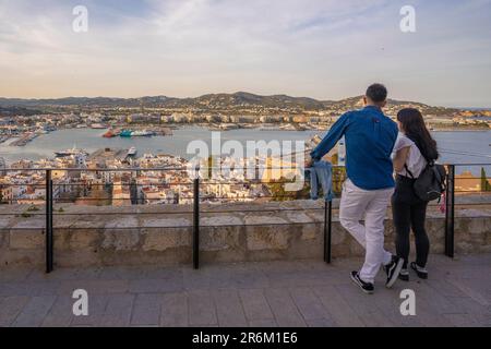 Couple avec vue imprenable sur le port, le quartier Dalt Vila et les remparts de la ville, site classé au patrimoine mondial de l'UNESCO, la ville d'Ibiza, l'Eivissa, les îles Baléares Banque D'Images