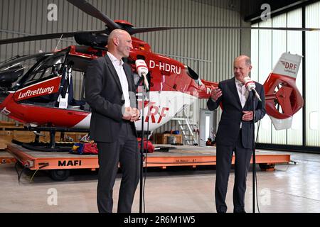 Nuremberg, Allemagne. 10th juin 2023. Le chancelier allemand OLAF Scholz (SPD) visite les deux stations de la DRF Lufttrettung à Nuremberg et parle à côté de Krystian Pratz, président du conseil d'administration de la DRF Lufttrettung. Derrière eux se trouve un hélicoptère de sauvetage avec treuil de sauvetage. La DRF Luftrettung exploite 29 stations en Allemagne, et des hélicoptères avec treuils de sauvetage sont utilisés dans quatre stations de l'organisation à but non lucratif Credit: PIA Bayer/dpa/Alay Live News Banque D'Images