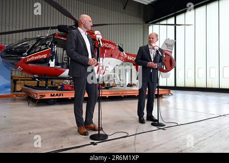 Nuremberg, Allemagne. 10th juin 2023. Le chancelier allemand OLAF Scholz (SPD) visite les deux stations de la DRF Lufttrettung à Nuremberg et parle à côté de Krystian Pratz, président du conseil d'administration de la DRF Lufttrettung. Derrière eux se trouve un hélicoptère de sauvetage avec treuil de sauvetage. La DRF Luftrettung exploite 29 stations en Allemagne, et des hélicoptères avec treuils de sauvetage sont utilisés dans quatre stations de l'organisation à but non lucratif Credit: PIA Bayer/dpa/Alay Live News Banque D'Images