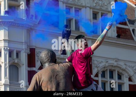 Londres, Royaume-Uni. 8th juin 2023. Un supporter de West Ham United assis sur la sculpture des champions sur Barking Road tient une grenade de fumée avant un défilé de victoire de l'UEFA Europa Conference League. West Ham a battu l'ACF Fiorentina lors de la finale de la Ligue de la Conférence Europa de l'UEFA le 7 juin, remportant leur premier trophée majeur depuis 1980. Crédit : Mark Kerrison/Alamy Live News Banque D'Images