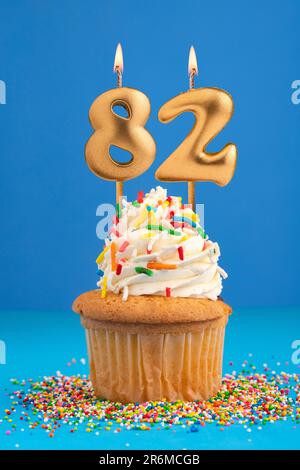 Gâteau d'anniversaire avec bougie numéro 82 - fond bleu Banque D'Images
