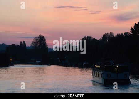 Henley-on-Thames, 9 juin 2023 : coucher de soleil sur la Tamise près de Henley, avec un bateau de fête naviguant vers la ville. Anna Watson/Alay Live News Banque D'Images