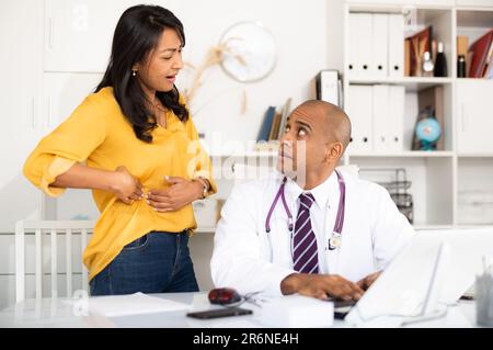 Le médecin examine le patient avec une douleur aiguë Banque D'Images