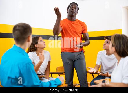 Groupe d'étudiants discutant avec animation en étant assis en cercle dans l'auditorium Banque D'Images