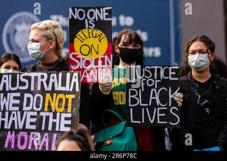 MELBOURNE, AUSTRALIE - 06 JUIN : les manifestants qui prennent position sur la justice noire portent des masques faciaux et tiennent des pancartes lors d'un rassemblement Black Lives Mater le 06 juin 2020 à Melbourne, en Australie. Cet événement a été organisé pour se rassembler contre les décès d'autochtones en détention en Australie, ainsi que dans le cadre de manifestations à travers les États-Unis à la suite du meurtre d'un homme noir non armé George Floyd aux mains d'un agent de police à Minneapolis, dans le Minnesota. Banque D'Images