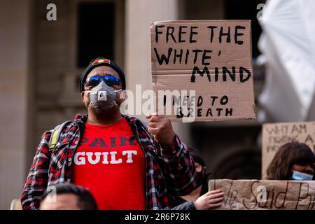 MELBOURNE, AUSTRALIE - 06 JUIN : un manifestant portant un masque facial tient un panneau lors d'un rassemblement de Black Lives Mater le 06 juin 2020 à Melbourne, en Australie. Cet événement a été organisé pour se rassembler contre les décès d'autochtones en détention en Australie, ainsi que dans le cadre de manifestations à travers les États-Unis à la suite du meurtre d'un homme noir non armé George Floyd aux mains d'un agent de police à Minneapolis, dans le Minnesota. Banque D'Images