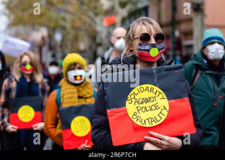 MELBOURNE, AUSTRALIE - JUIN 06 : une femme portant un masque aux couleurs du drapeau aborigène, se tient en solidarité contre la brutalité policière lors d'un rassemblement Black Lives Mater le 06 juin 2020 à Melbourne, en Australie. Cet événement a été organisé pour se rassembler contre les décès d'autochtones en détention en Australie, ainsi que dans le cadre de manifestations à travers les États-Unis à la suite du meurtre d'un homme noir non armé George Floyd aux mains d'un agent de police à Minneapolis, dans le Minnesota. Banque D'Images