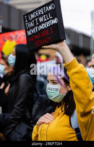 MELBOURNE, AUSTRALIE - 06 JUIN : une femme portant un masque facial tient un petit écriteau lors d'un rassemblement de Black Lives Mater le 06 juin 2020 à Melbourne, en Australie. Cet événement a été organisé pour se rassembler contre les décès d'autochtones en détention en Australie, ainsi que dans le cadre de manifestations à travers les États-Unis à la suite du meurtre d'un homme noir non armé George Floyd aux mains d'un agent de police à Minneapolis, dans le Minnesota. Banque D'Images