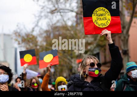 MELBOURNE, AUSTRALIE - JUIN 06 : une femme portant un masque aux couleurs du drapeau aborigène, se tient en solidarité contre la brutalité policière lors d'un rassemblement Black Lives Mater le 06 juin 2020 à Melbourne, en Australie. Cet événement a été organisé pour se rassembler contre les décès d'autochtones en détention en Australie, ainsi que dans le cadre de manifestations à travers les États-Unis à la suite du meurtre d'un homme noir non armé George Floyd aux mains d'un agent de police à Minneapolis, dans le Minnesota. Banque D'Images