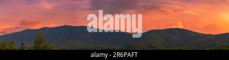 Panorama. Des nuages chauds et éclatants apparaissent autour du coucher du soleil sur une crête dans les Smoky Mountains des Appalaches près de Townsend, TN. Orange, rouge et jaune Banque D'Images