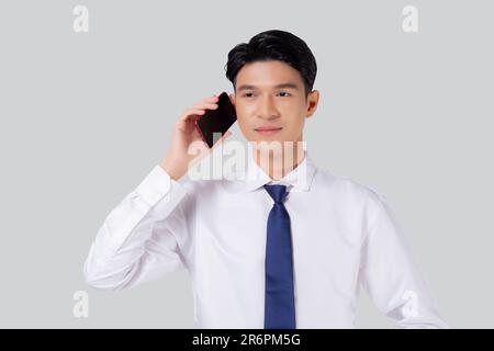 Portrait d'un jeune homme d'affaires asiatique à l'aide d'un smartphone parlant isolé sur fond blanc, homme d'affaires debout et parler avec un smartphone avec confiden Banque D'Images