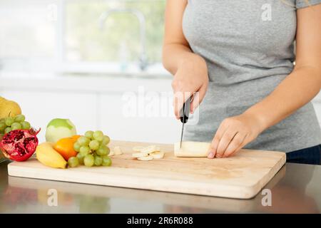 Femmes mains, cuisine et fruits pour la santé nourriture et nutrition pour la perte de poids alimentation et la santé à la maison. Cuisine, fruits et hacher de la banane dans une maison Banque D'Images