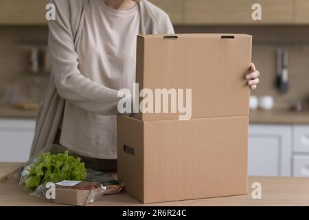 Prise de vue de la femme produisant des légumes frais emballés dans une boîte Banque D'Images