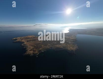 Une île baignée de soleil située dans une mer turquoise tranquille, vue d'en haut Banque D'Images