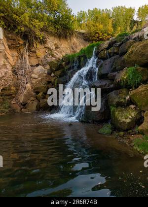 Cette superbe image capture une cascade qui coule sur des rochers déchiquetés et qui s'abatte sur le terrain accidenté Banque D'Images