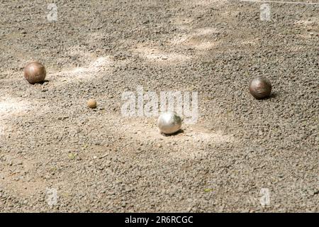 Boules de pétanque (boules) près de la balle de cible de cric sur terrain de pétanque en gravier Banque D'Images