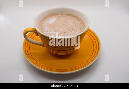 Tasse à café jaune et soucoupe isolées sur fond blanc. Avec masque Banque D'Images