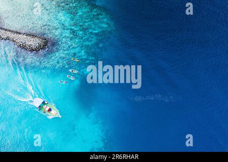 Une vue aérienne d'une belle plage et d'une eau bleu limpide sous le ciel bleu des Maldives Banque D'Images