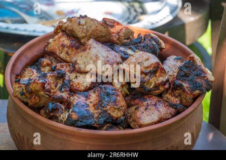 Bol en argile rempli de viande grillée juteuse fraîchement cuite. Barbecue d'été Banque D'Images