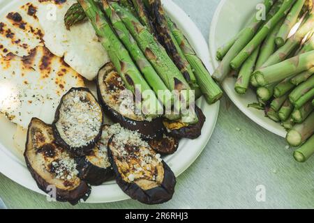 Délicieux légumes grillés sur des plats blancs en recycable. Aubergine grillée, asperges, fromage. Barbecue d'été Banque D'Images