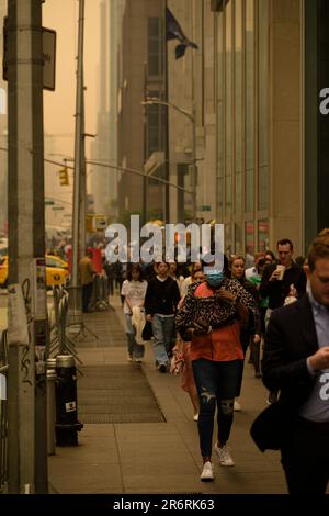 Les piétons dehors pendant la qualité dangereuse de l'air à New York causée par les feux de forêt canadiens. Photo prise aux 46th et 6th avenue, 7 juin 2023. Banque D'Images