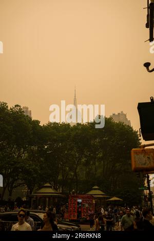 Les piétons dehors pendant la qualité dangereuse de l'air à New York causée par les feux de forêt canadiens. Photo prise à 41st et 6th Avenue, près de Bryant Park, juin Banque D'Images