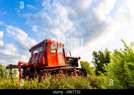 le tracteur rouge de l'ancien modèle se trouve dans le champ. tracteur rouge. ancien tracteur. tracteur dans le champ. chenille Banque D'Images