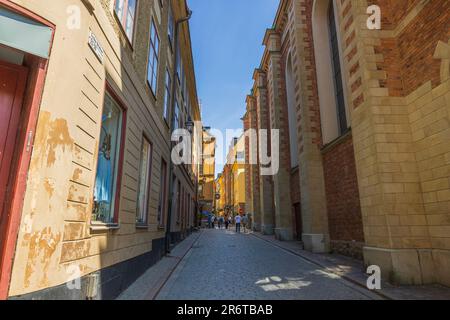 Vue sur la rue étroite entre les bâtiments jaunes et la route pavée. Suède. Stockholm. Banque D'Images