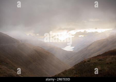 Paysage de montagne mystique en Suisse, orné de brouillard et d'un ciel nuageux, créant une atmosphère éthérée et captivante Banque D'Images