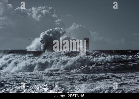 Une énorme vague de tempête éclabousse sur la jetée et la balise - filtre infrarouge utilisé Banque D'Images